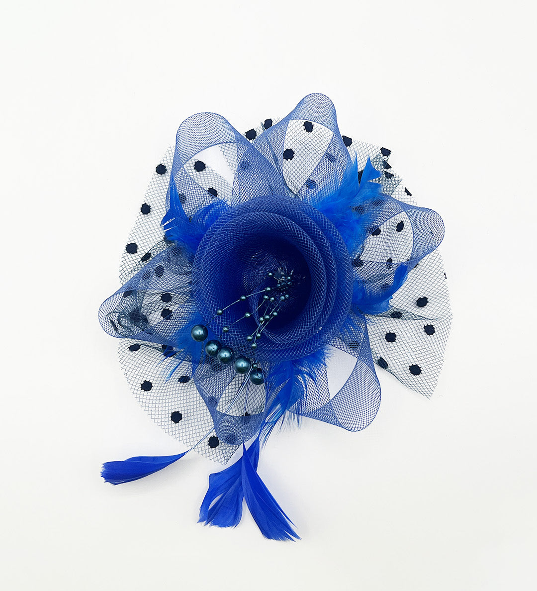A royal blue fascinator hair accessory featuring a layered mesh flower, polka-dotted tulle, feathers, and tassels, photographed on a clean white background.